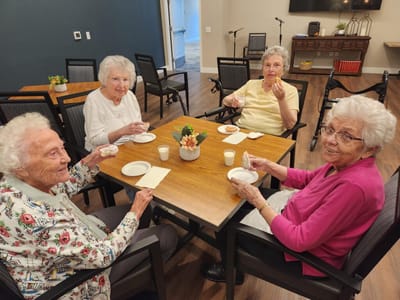 Residents enjoying dessert and conversation in a common area.