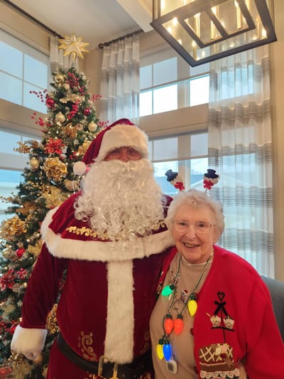 Resident with Santa in a festive interior