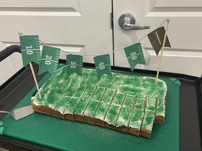 Football-themed cake with decorative flags
