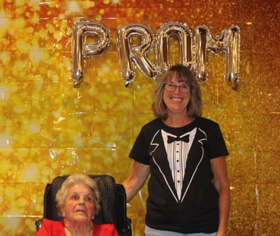 Resident and staff member posing at prom event.