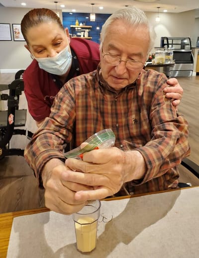 Staff assisting resident with dessert preparation