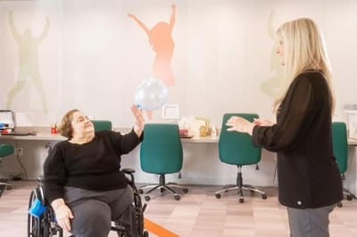 Resident interacting with staff in a common area.