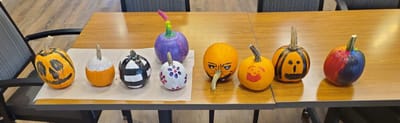 Decoratively painted pumpkins on a table.