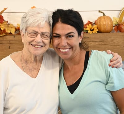 Senior resident smiling with staff member.