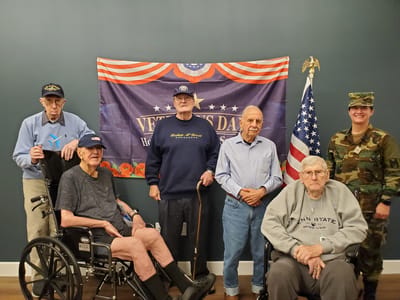Veterans celebration with residents and a military member.