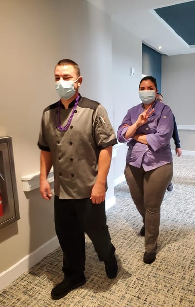 Staff members walking through the facility hallway.
