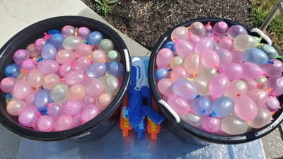 Buckets filled with colorful water balloons.
