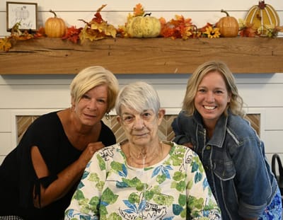 Two staff members with a resident in a cheerful setting.
