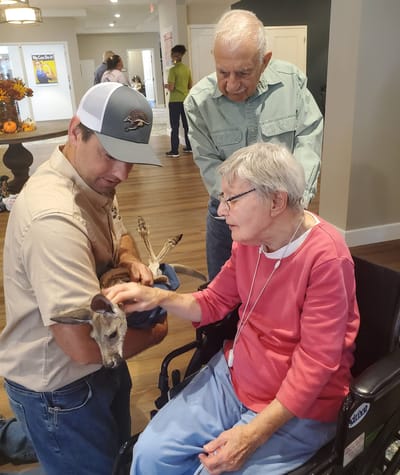 Residents interacting with a small animal indoors.