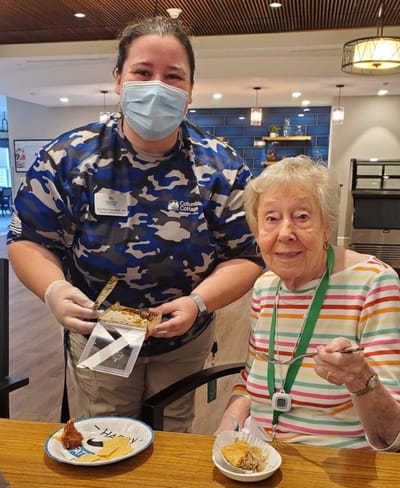 Staff member serving dessert to a resident