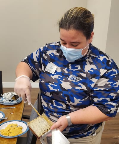 Staff member preparing a snack in a communal setting.