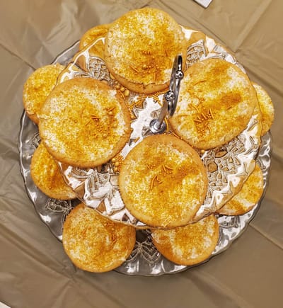 A silver platter with decorated cookies.
