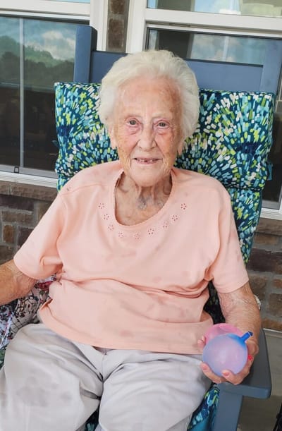 Resident enjoying time outdoors with a water balloon