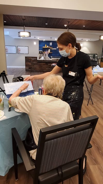 Resident painting with staff guidance