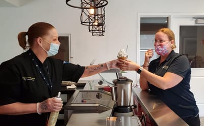 Staff serving a dessert treat in the facility kitchen.