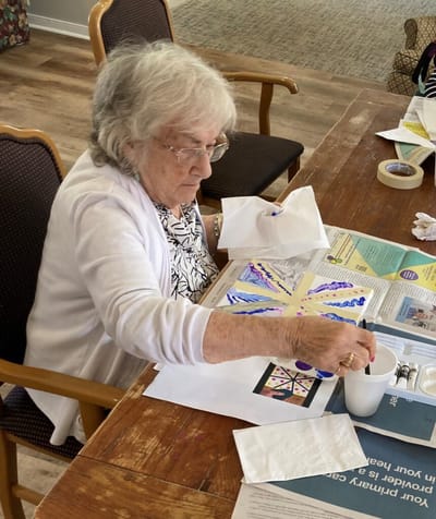 Senior woman painting at a table