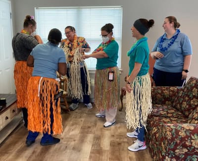 Staff engaged in a fun activity wearing colorful skirts.