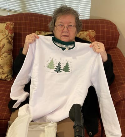 Resident holding a holiday-themed shirt.