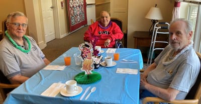 Residents enjoying snacks at a dining table.