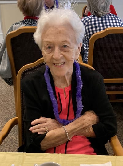 Smiling resident in a dining area at the facility.