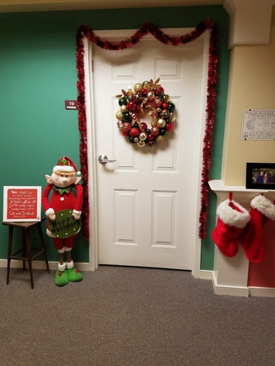 Festively decorated door with stockings and wreath.