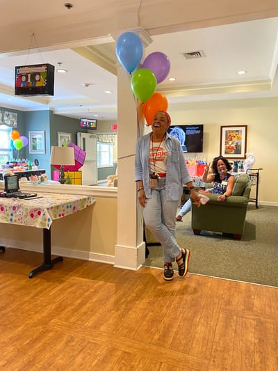 Celebration party with colorful balloons and residents.