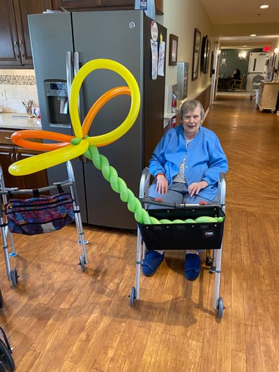Resident with a colorful balloon decoration.