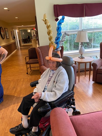 Resident with balloon hats in a common area.