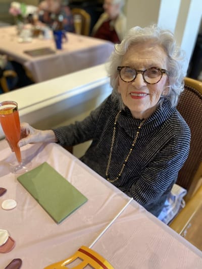 Senior woman enjoying a drink in the dining area.