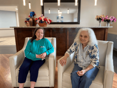 Two residents seated in a cozy common area.