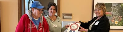 Staff and resident celebrating an award presentation.