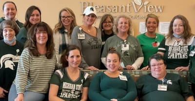 Staff members posing together in a common area