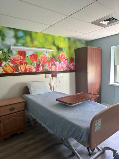 Interior view of a resident room with floral wallpaper.