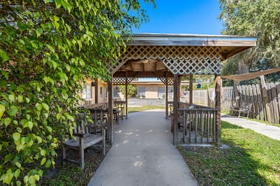 Outdoor seating area with wooden tables and chairs.