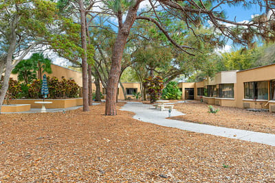 Outdoor pathway surrounded by trees and landscaping.