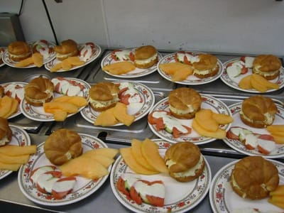 Platters of sandwiches and fruit slices.