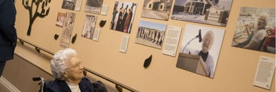 Resident enjoying photographs in a hallway