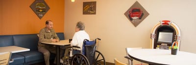 Resident and staff member chatting in a common area.