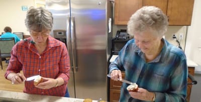 Residents decorating cupcakes in a kitchen