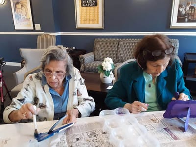 Two residents painting in a common area