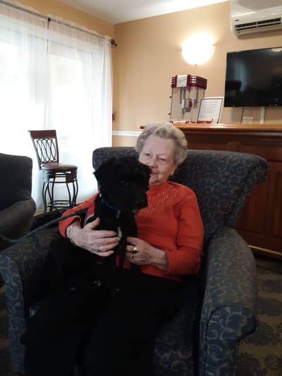 Resident sitting in a chair with a small dog