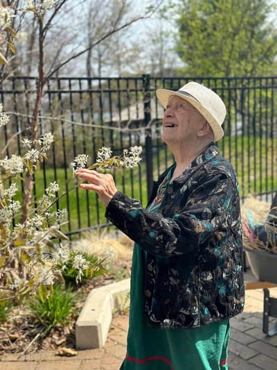 A resident enjoying time outdoors among blooming flowers