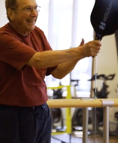 An elderly man engaging in physical activity indoors