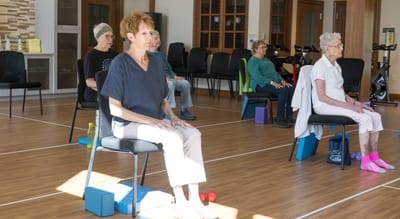 Residents participating in a seated exercise class