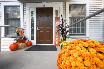 Entrance of a senior living facility decorated for fall