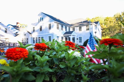 Exterior view of The Haven at Lee with flowers and flag
