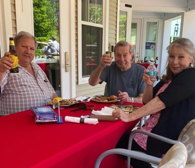 Residents enjoying a meal outdoors at a table