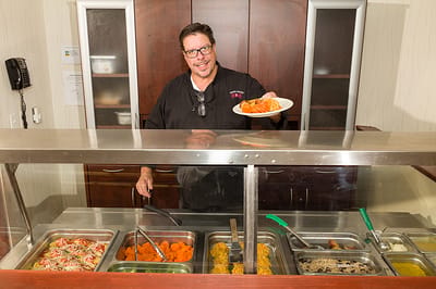 Staff member serving food in the dining area