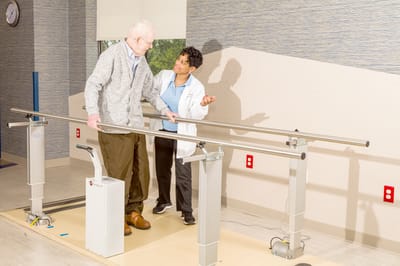 A resident receiving assistance in a rehabilitation session
