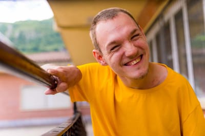 A resident smiling while leaning on a railing